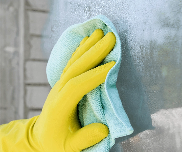 pessoa limpando vidro com luvas e pano adequado usando jimo limpa vidros