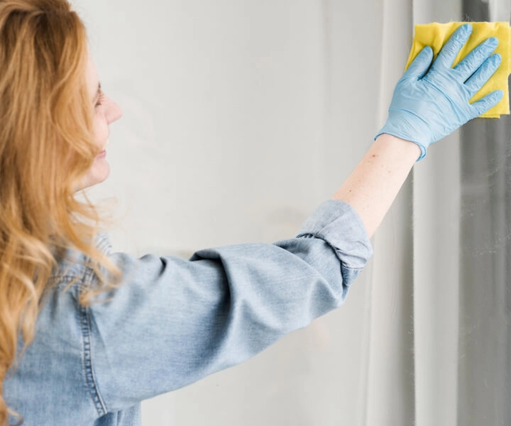 mulher limpando vidro com produto JIMO limpa vidro