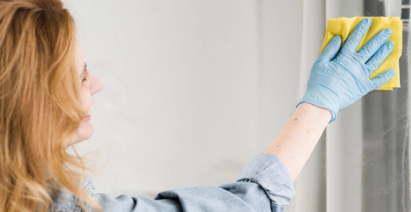 mulher limpando vidro com produto JIMO limpa vidro